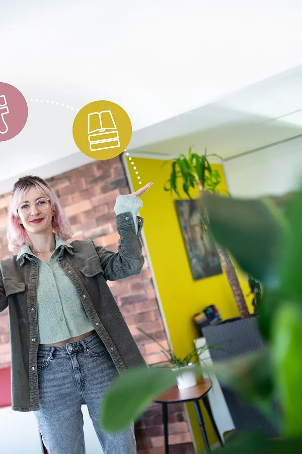 Frau reckt im Büro die Arme hoch, darüber schweben Symbole für Gestaltung und Branding