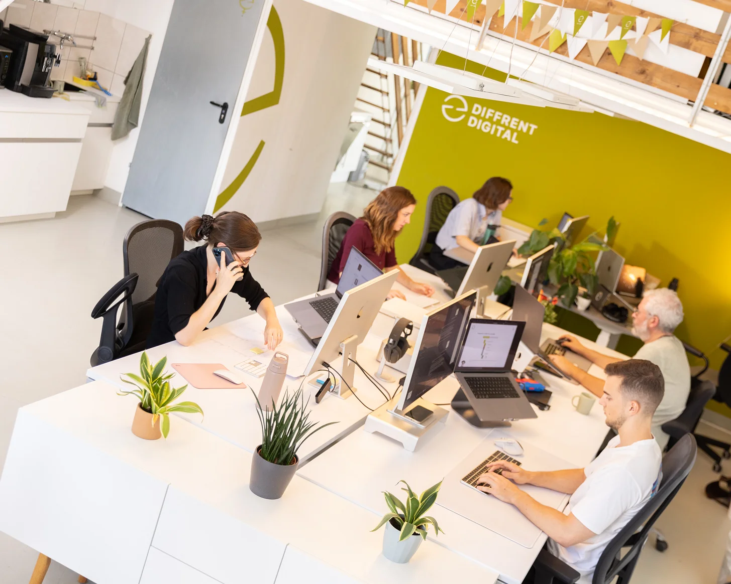 Blick von der Empore auf das Büro mit dem Team an den Schreibtischen