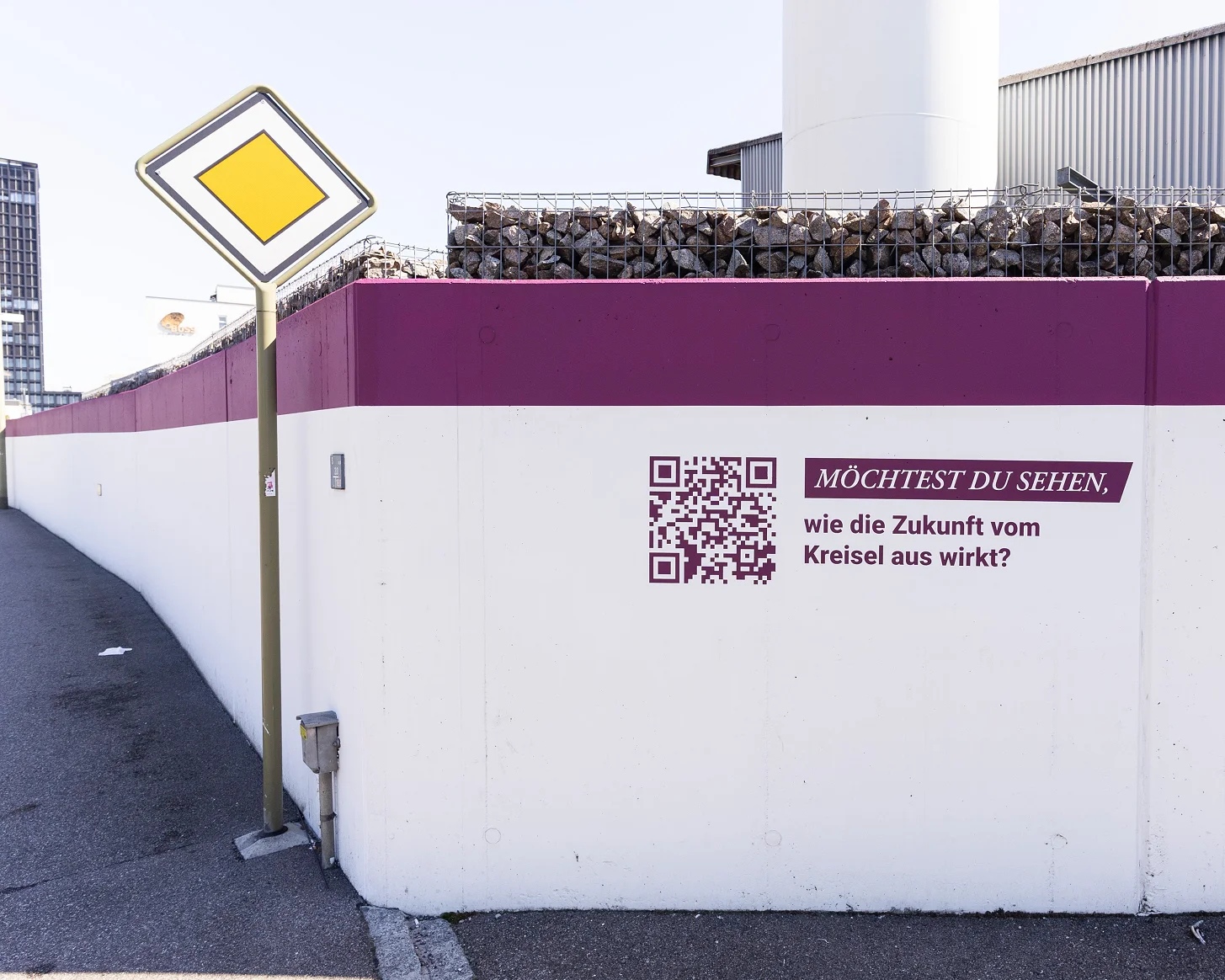 Station des Areal-Rundgangs an der Mauer: QR-Code neben der Frage «Möchtest du sehen, wie die Zukunft vom Kreisel aus wirkt?»