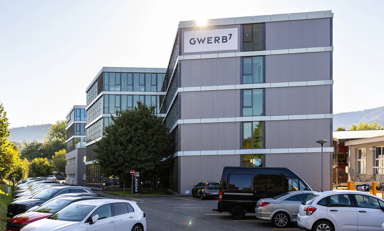 Das GWERB7-Gebäude mit Fassadenbeschriftung, davor parkierte Autos