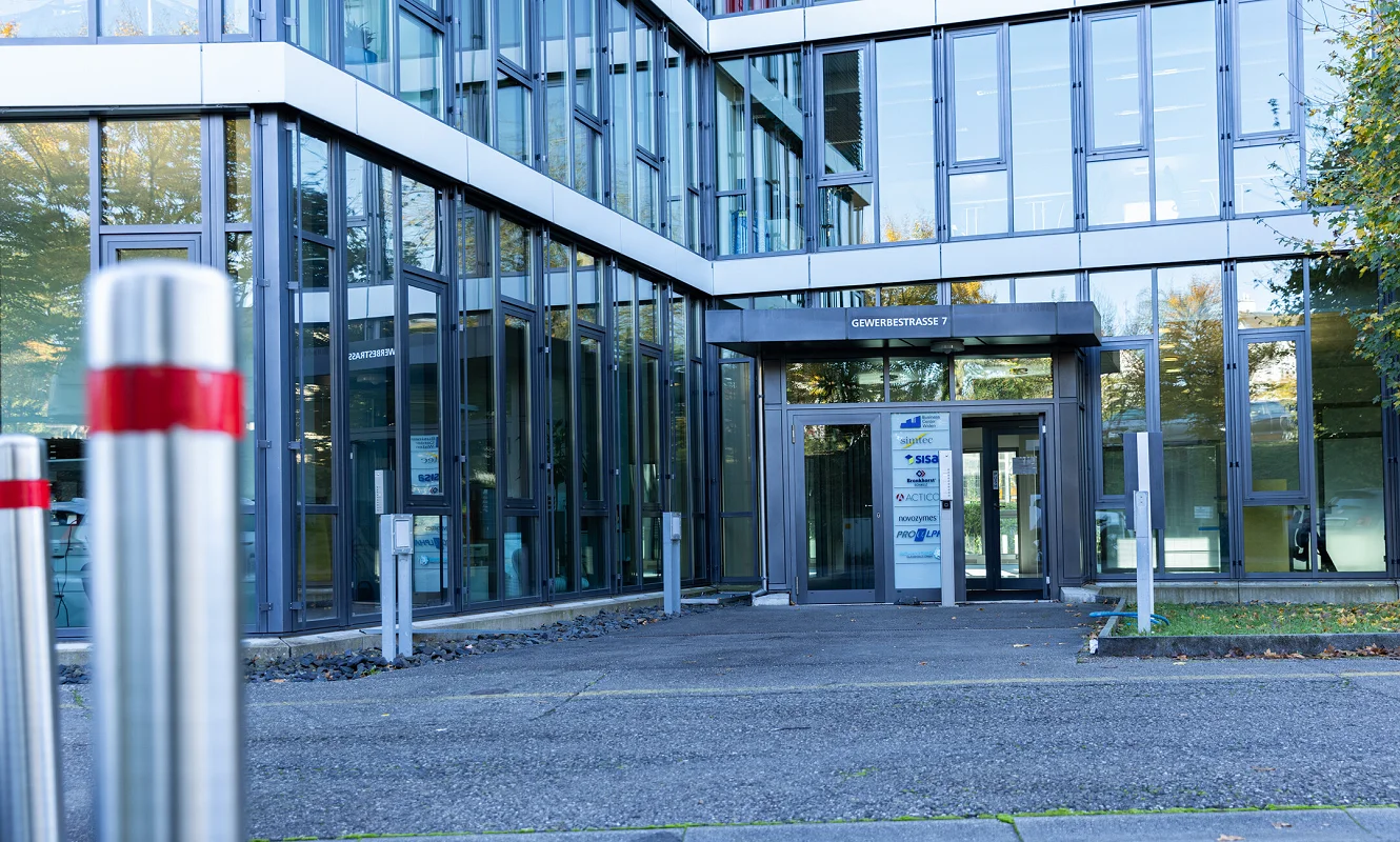Eingang der Gewerbestrasse 7 mit Glasfront und Pollern