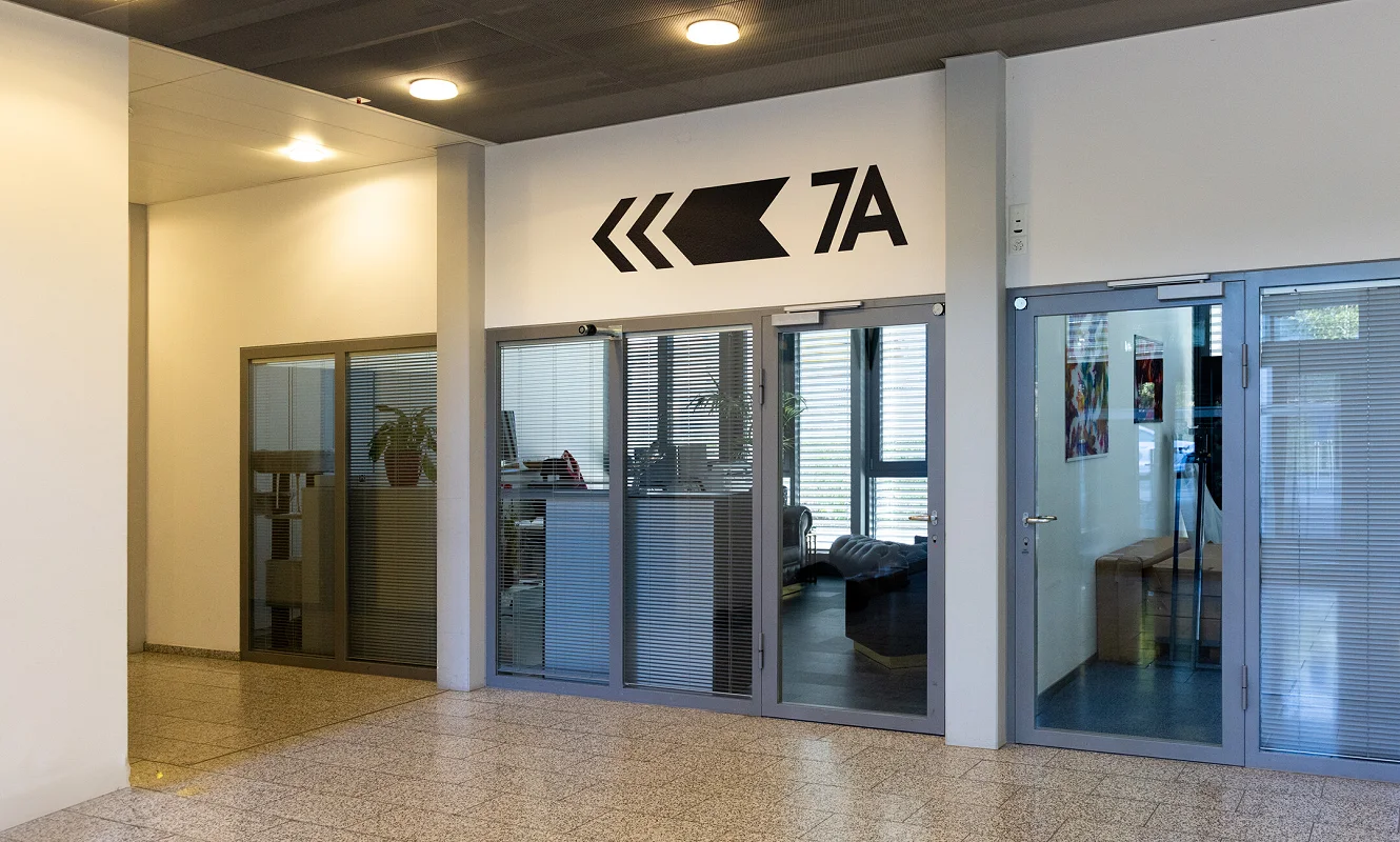 Eingang 7A mit schwarzem Richtungspfeil und Beschriftung an der Wand