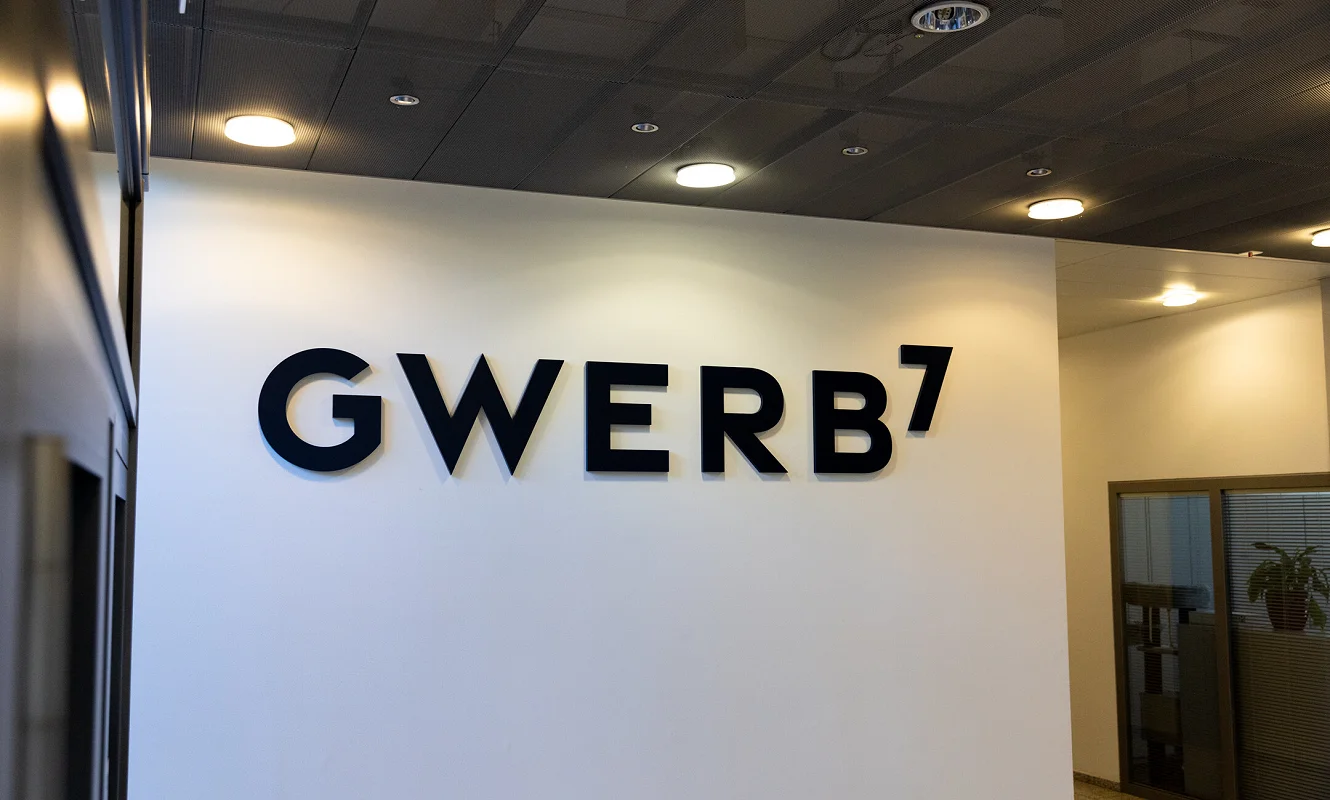 Schwarze Wortmarke GWERB7 als Wandbeschriftung im Eingangsbereich
