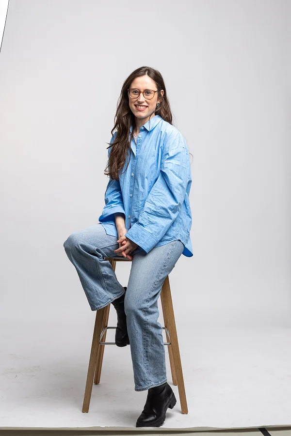 Melina sitzt im Fotostudio auf einem Hocker zwischen den Studioleuchten