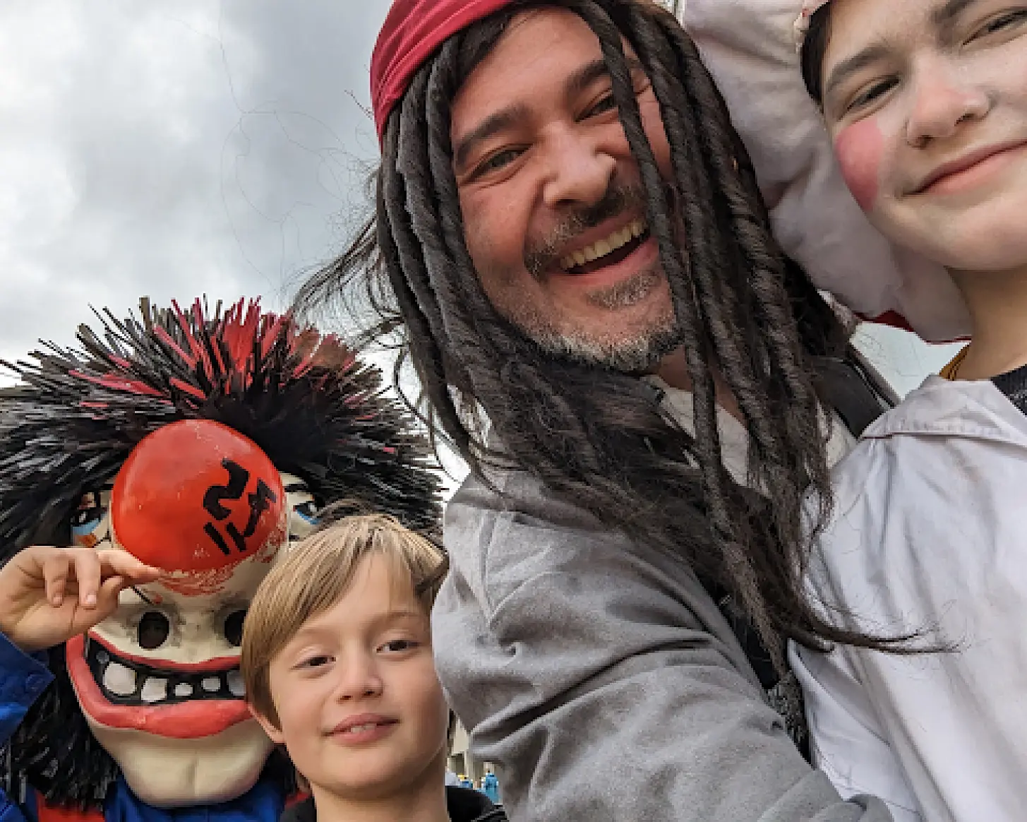 Patrick an der Fasnacht mit zwei Kindern, links eine Waggis-Maske